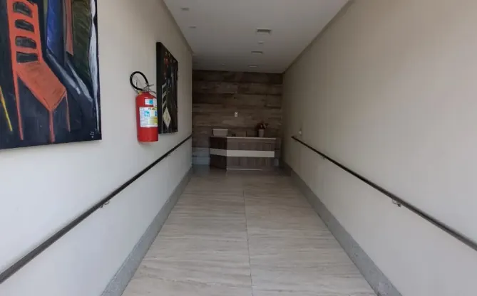 Corredor de entrada do prédio com rampa e corrimão