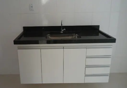 Armário branco de marcenaria com bancada de granito preto na cozinha