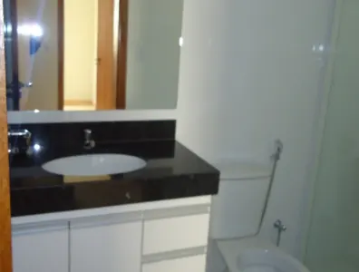 Pia do banheiro com bancada de granito preto e armário